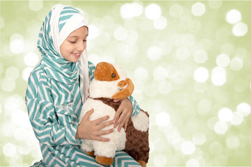 Happy little girl playing with her sheep toy - celebrating Eid ul Adha - Happy Sacrifice Feast