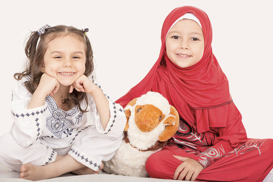Happy little Muslim girls playing with sheep toy - celebrating Eid ul Adha - Happy Sacrifice Feast