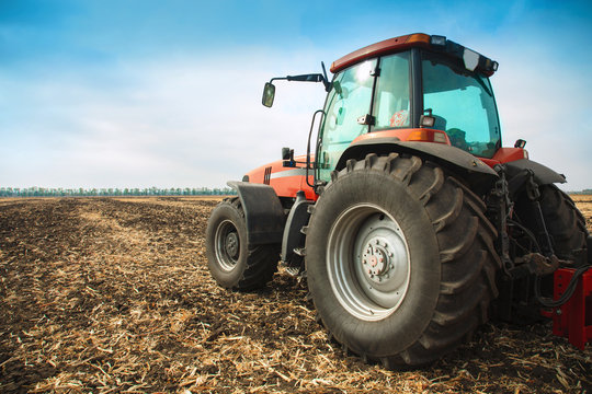 Modern Red Tractor In The Field.