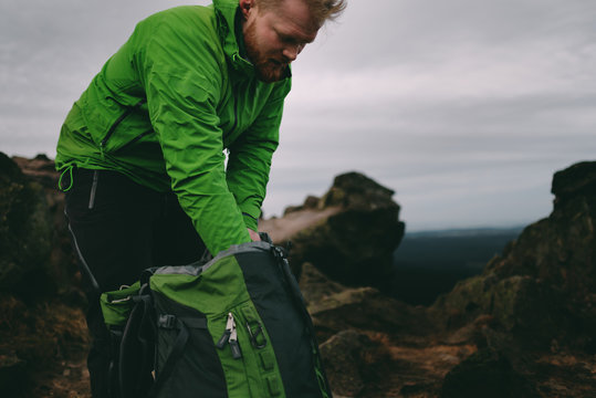 Wanderer sucht in seinem Rucksack