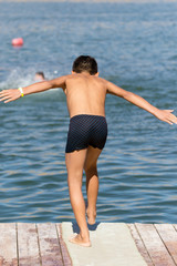 A man dives from shore to lake