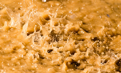 Rain drops fall into a dirty puddle