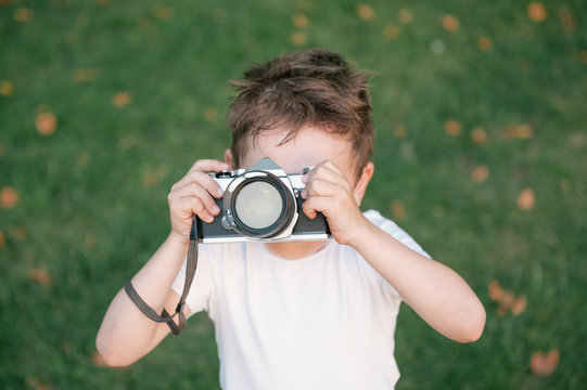 kid taking a picture using film camera