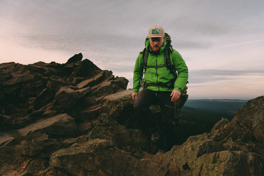 Wanderer auf einem Felsvorsprung im Harz bei Sonnenaufgang