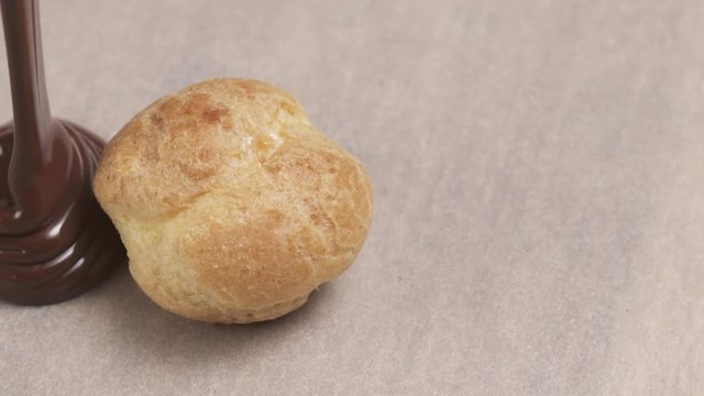 Slow motion of fine dark chocolate pour over profiterole