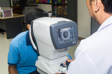 Man looking at eye test machine in physical examination