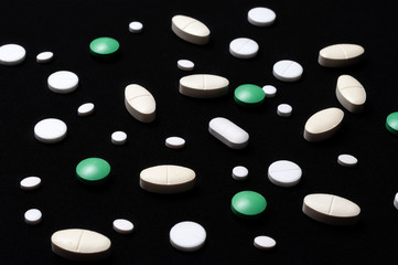 pills on black background with a medical syringe
