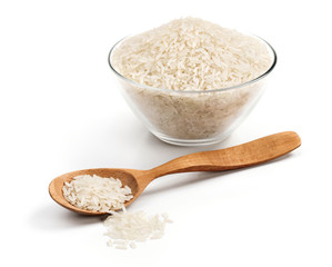Wooden spoon and glass bowl with heap of parboiled rice isolated on white background. Close up, high resolution product. Healthy food.