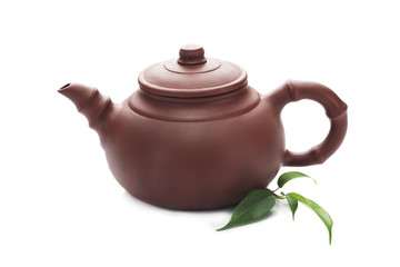 Teapot with green leaves isolated on white
