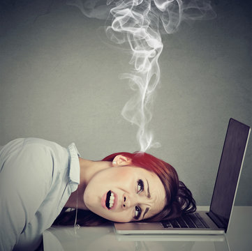 Stressed employee woman with overheated brain using laptop