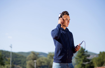 White caucasian young male wearing headphones and phone looking away