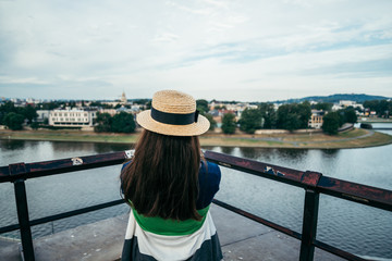 woman standing on the pier in the city and looking on the river
