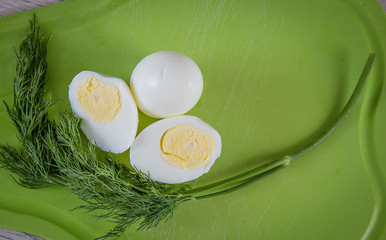 boiled egg and dill on cutting board