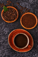 Coffee cup, beans, ground powder and sugar.