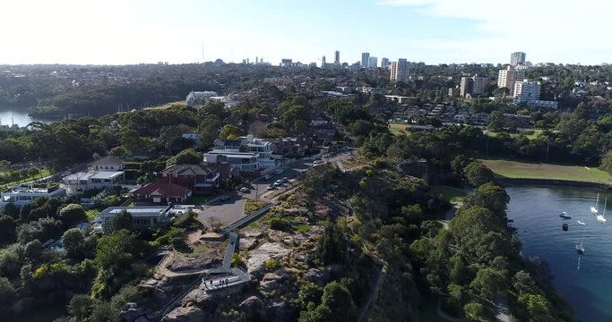 From rocky cliff lookout of Waverton to Berry Bay waters towards Sydney City CBD landmarks.
