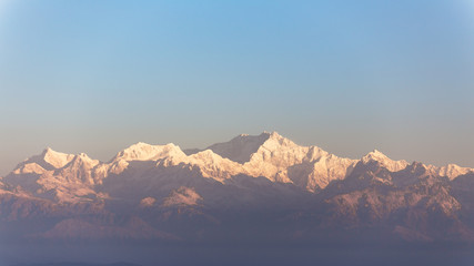 Fototapeta na wymiar Close-up Kangchenjunga mountain in the morning with blue and orange sky that view from The Tiger Hill in winter at Tiger Hill, Darjeeling. India.