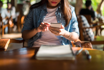 Young asian woman using smartphone in cafe.