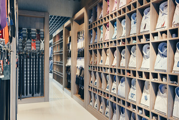 interior of boutique shop for the sale of business suits. On the shelves a large selection of colorful shirts