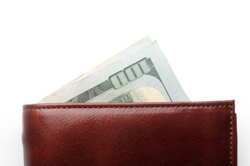 corner of banknotes worth a hundred dollars sticks out of a red leather wallet