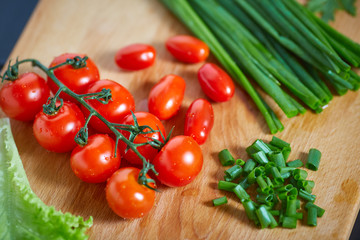 Fresh and tasty tomatoes, salad, onion on wooden cutting board