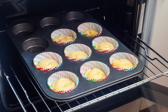 Muffin Cups With Cake Batter Arranged In Baking Tray Overhead