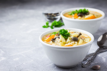 Creamy barley mushroom soup on concrete, slate or stone background. Selective focus, space for text.