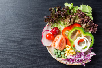 still life photography : top view of various vegetable or salad in dish on space of black wood pattern pvc sheet background