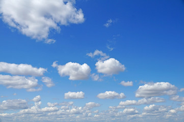 Naklejka na ściany i meble Fluffy white clouds on a blue sky.