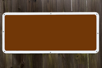 Blank brown sign on wood plant fence. Horizontal.