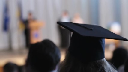 Graduate receiving diploma at stage, students watching graduation ceremony - Powered by Adobe
