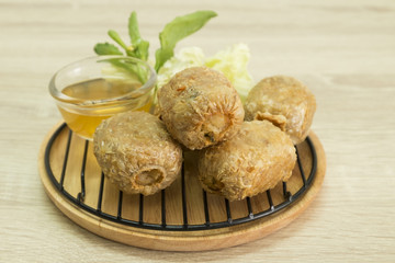 FRIED CRAB DUMPLING ON GRILL AND WOOD PLATE
Fried crab dumpling on grill and wood plate with sweet and sour sauce.