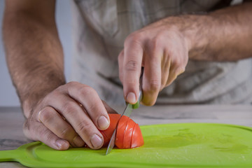 cutting tomato on green cutting board