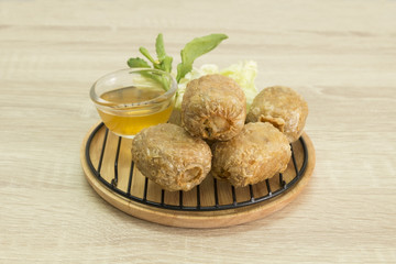 FRIED CRAB DUMPLING ON GRILL AND WOOD PLATE
Fried crab dumpling on grill and wood plate with sweet and sour sauce.
