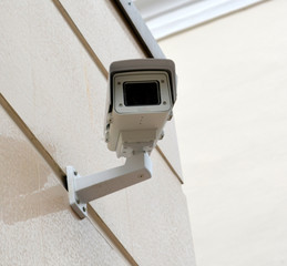 Security camera on the wall of an office building in the city, technology
