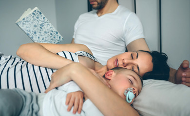 Man reading while his wife and son are sleeping