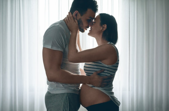 Man embracing and kissing his pregnant woman