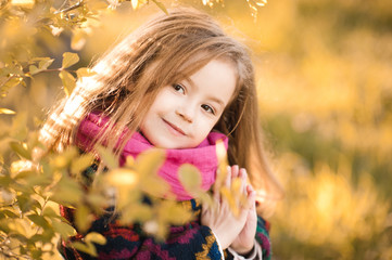 Naklejka premium Smiling kid girl 4-5 year old posing outdoors in autumn. Looking at camera.