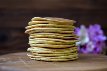 Tasty homemade pancakes with cream and raspberry. On wooden table. Village kitchen