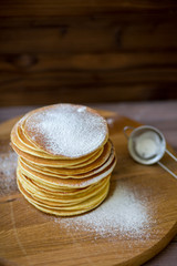 Tasty homemade pancakes with cream and raspberry. On wooden table. Village kitchen