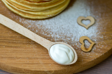 Tasty homemade pancakes with cream and raspberry. On wooden table. Village kitchen