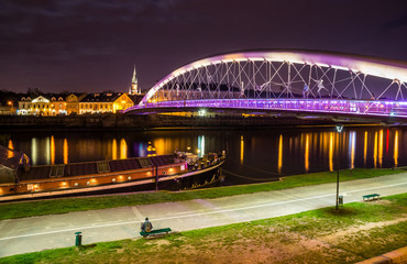 Fototapeta premium Bernatka footbridge over Vistula river at night in Cracow, Poland