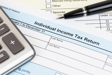 Tax form with pen and calculator; document are mock-up