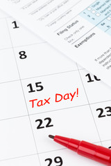 Tax day on calendar with red marker pen, and tax form