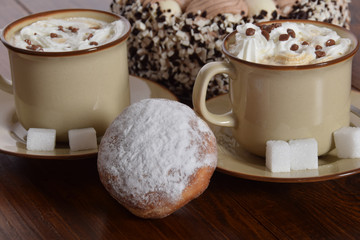 Coffee with whipped cream and chocolate and coffee cake  and donut with icing sugar