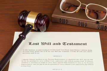 Last will and testament with wooden judge gavel; document is mock-up not real