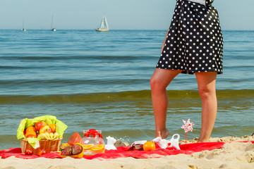 Woman in retro dress having picnic near sea