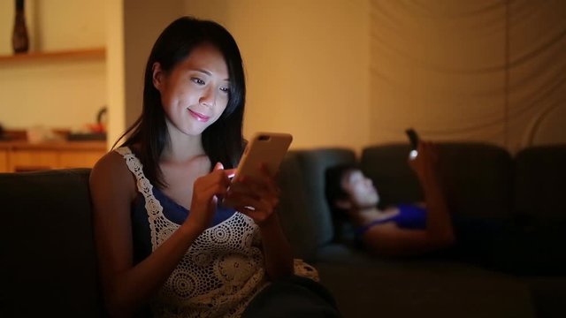 Couple using cellphone at home