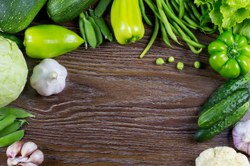 Green vegetables harvest, raw healthy organic food on wooden background