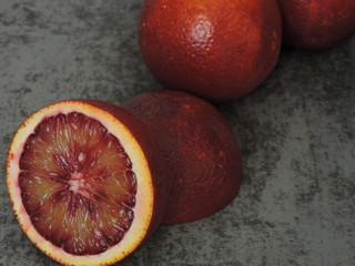 Red orange, cut in half on a gray background. Close up. Copy space