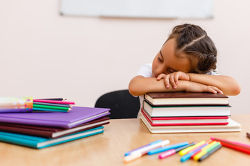 little schoolgirl sleep in classroom near blackboard